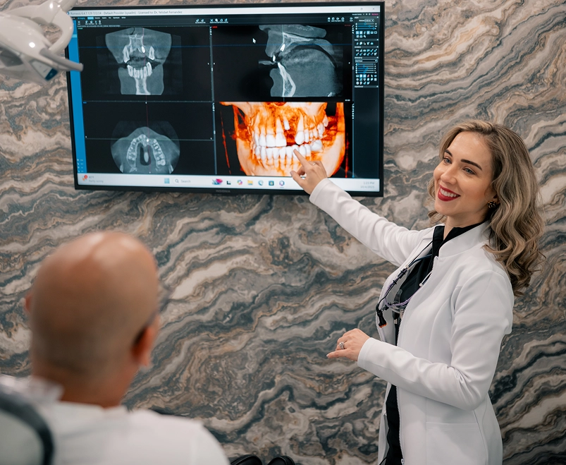 Dentist explaining dental X-rays to patient on monitor